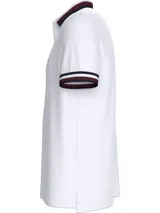 Chomba blanca de algodón orgánico con cuello polo a rayas azul marino y rojo. Tiene cartera de dos botones y logo bordado en el pecho.