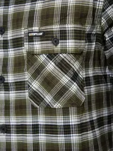 Camisa de manga larga con estampado a cuadros en tonos rojo, blanco, azul y gris. Tiene dos bolsillos en el pecho con cierre de botón, puños ajustables con botón y un paño de microfibra oculto en el dobladillo delantero.