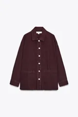 Sobrecamisa de Zara Woman Collection confeccionada en algodón 100%, color borgoña. Tiene cuello solapa, manga larga con puño, bolsillos de plastrón en el delantero y cierre frontal con botones metálicos.