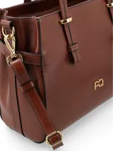 Cartera tipo shopper color crema, de cuero liso, con doble asa corta y correa larga extraíble. Tiene cierre principal, bolsillo externo con cierre, bolsillo interno con cierre y forro textil.