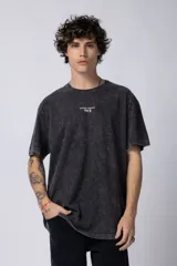 Remera negra con efecto gastado, corte holgado y estampa frontal con la frase 'Astral Energy' en blanco.