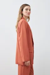 Blazer color ladrillo de lyocell con solapas, bolsillos delanteros y corte recto.