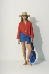 Camisa color rojo de manga larga con cuello clásico y cierre frontal con botones.