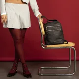 Mochila color beige de símil cuero con doble apertura superior con cierre. Incluye dos bolsillos al frente con cierres metálicos, asa rígida de mano y correa de galón. En la espalda correas de galón regulables.