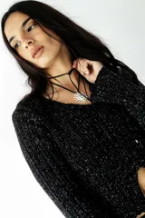 Buzo negro de lurex con tajo delantero y mangas largas.