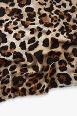 Pañuelo rectangular con estampado de leopardo y terminaciones deshilachadas.