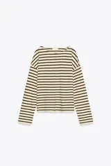 Camiseta de manga larga confeccionada con 30% de lino, cuello redondo y bajo con aberturas laterales.