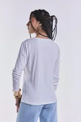 Remera blanca de manga larga con cuello redondo y corte recto.