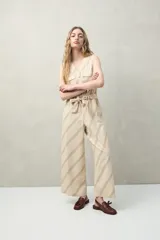 Mono enterito de algodón con rayas verticales color verde claro y beige, con cuello en V, sin mangas, con cierre frontal con botones y cinturón de lazo.