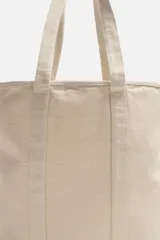 Bolso tipo shopper color crudo, fabricado en tejido de algodón. Tiene doble asa de hombro y un bolsillo interior plano.
