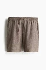 Short marrón claro en tejido liviano de lino y algodón. Modelo con elástico revestido y cordón para ajustar en la cintura, cierre con botón, bolsillos laterales y bolsillo insertado atrás.