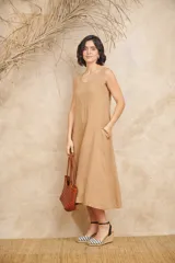 Vestido midi lila de lino, corte amplio, sin mangas y con bolsillos laterales con volados.