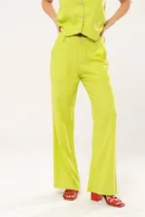 Pantalón verde lima de lino imperial con lurex, tiro medio, corte palazzo, bolsillos delanteros y traseros, cierre frontal con cremallera y botón.
