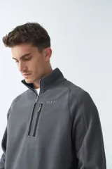 Buzo polar de algodón color bordó, con cuello elevado, medio cierre frontal, bolsillo con cierre en el pecho y logo estampado.