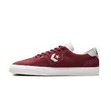 Zapatillas de gamuza color burdeos con detalles en blanco y suela de goma.