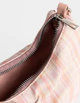 Bandolera de cuerina estampada con diseño escocés en tonos rosa y blanco. Presenta frunce y lazo frontal con moño, manija superior regulable con hebilla y cierre superior.