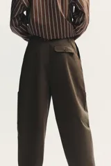 Pantalón cargo negro de corte amplio con cintura ajustable con cordón, bolsillos laterales y bolsillos tipo parche en las piernas.