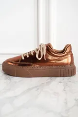 Zapatillas acordonadas color cobre metalizado, con suela marrón de goma.