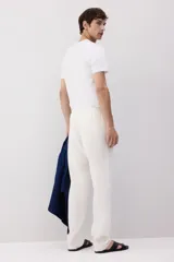 Pantalón blanco de lino liviano, corte recto, con elástico revestido y cordón ajustable en la cintura, bolsillos laterales y bolsillo trasero insertado.