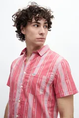 Camisa de manga corta confeccionada en 100% algodón, con estampado a rayas y bolsillo en el pecho.