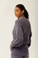 Cárdigan color marrón con tejido de punto acanalado, escote en V, cierre frontal con botones y mangas largas abullonadas.