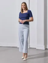 Pantalón wide leg con estampado de rayas verticales celestes y blancas, pretina con botón, bolsillos simulados en la parte delantera y ruedo con dobladillo.