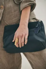 Neceser de cuero marrón con cierre superior y tirador de cuero con flecos.