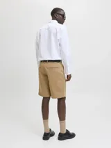 Bermuda chino color beige confeccionada en algodón, con bolsillos delanteros y traseros, y cierre con cremallera.