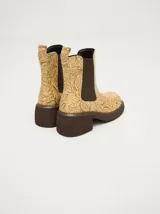 Botas Chelsea color beige con estampado floral, elástico lateral marrón y suela track color marrón.