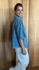 Sobrecamisa color gris oscuro de denim suave, con cuello clásico, cierre frontal con botones, mangas cortas y dos bolsillos de parche en el pecho.