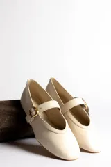 Ballerinas negras de cuero con tira sobre el empeine y hebilla dorada.