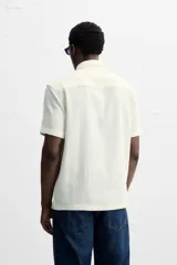 Camisa celeste de corte recto, manga corta y cuello solapa.