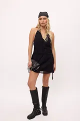 Minivestido negro con escote halter, espalda descubierta, cintura drapeada y falda con transparencias.