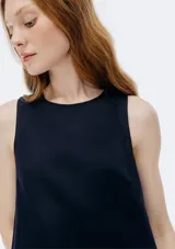 Vestido corto sin mangas color beige, de corte recto y cuello redondo.