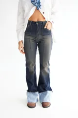 Pantalón jean oxford de tiro alto, color azul oscuro con desgaste en los muslos y rodillas. Presenta alforzas en el delantero y dobladillo en la botamanga.