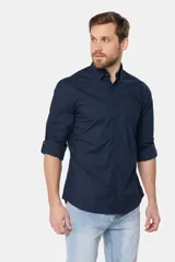 Camisa azul marino de manga larga con bolsillo en el pecho, confeccionada en algodón.
