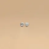Par de aros tipo botón (studs) de plata 925, con engarce inglés, engastados con circonias que forman una superficie redonda y brillante.