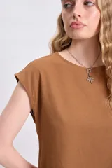 Blusa casual color tostado, confeccionada en lino, sin mangas y de corte holgado.