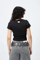 Remera corta negra de punto acanalado con escote en V fruncido y puntilla en el borde.