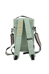 Mochila cilíndrica acolchada color gris, diseñada para transportar un equipo de mate (matero). Presenta un compartimento principal superior con cierre, un bolsillo frontal con cierre y un parche circular con texto y logo de Discovery. Incluye asa de mano superior y correa ajustable para llevar al hombro.
