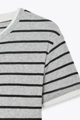 Camiseta gris con rayas horizontales negras, cuello redondo y mangas cortas.