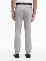 Pantalón chino slim fit color gris claro, con cinturón negro con hebilla metálica. Confeccionado con algodón orgánico.