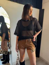 Short de jean color marrón con detalles de tela escocesa en los laterales y cinturón con hebilla metálica.