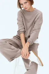 Pantalón de corte relajado color gris topo, confeccionado en felpa liviana de mezcla de algodón. Cuenta con cintura elástica fruncida, bolsillos laterales discretos y piernas rectas.