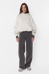 Buzo tipo hoodie color beige, de frisa gamuzada, con silueta oversize, bolsillo canguro, puños y cintura de ribb, capucha forrada con jersey y aplique de ojalillos en los puños.