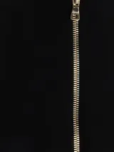 Vestido largo negro de estilo sastre con cuello halter y escote profundo en V. Presenta un diseño cruzado con doble botonadura de botones dorados en la parte frontal.