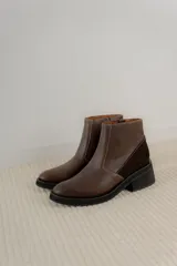 Bota corta color marrón con textura símil cuero de cocodrilo, caña baja, punta redondeada y taco cuadrado.