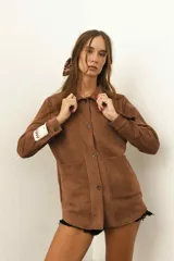 Camisa marrón de corte recto con botones y bolsillos frontales.