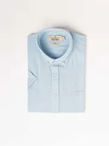 Camisa de hombre color verde oliva, de manga corta y corte clásico. Confeccionada en lino y poliéster, con cuello abotonado y bolsillo en el pecho.