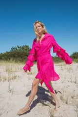 Vestido camisero fucsia con mangas cascada y cinturón de lazo.